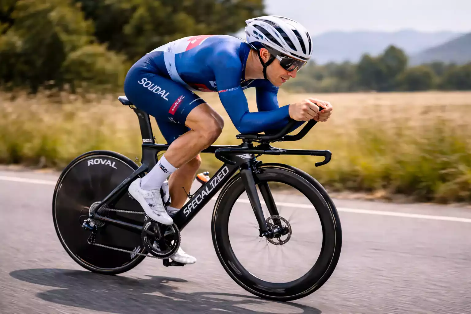 Ciclista contrarrelojista en posición aerodinámica con casco aero y bicicleta de crono